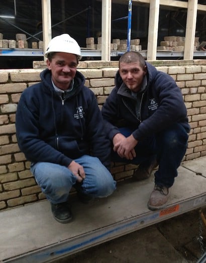 Peter and Mark stand in front of their freshly-constructed foundation wall despite the freezing temperatures outside. Ambient temperature inside the protected work site remains constant at 50 F.